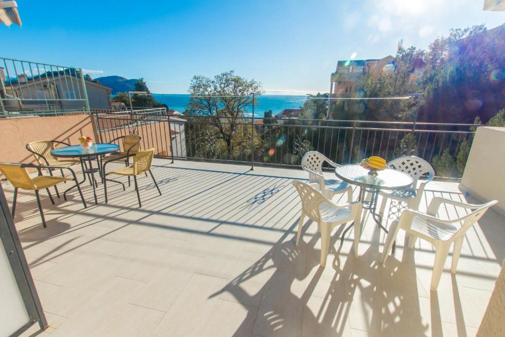 a patio with tables and chairs on a balcony at Apartments Petković in Petrovac na Moru