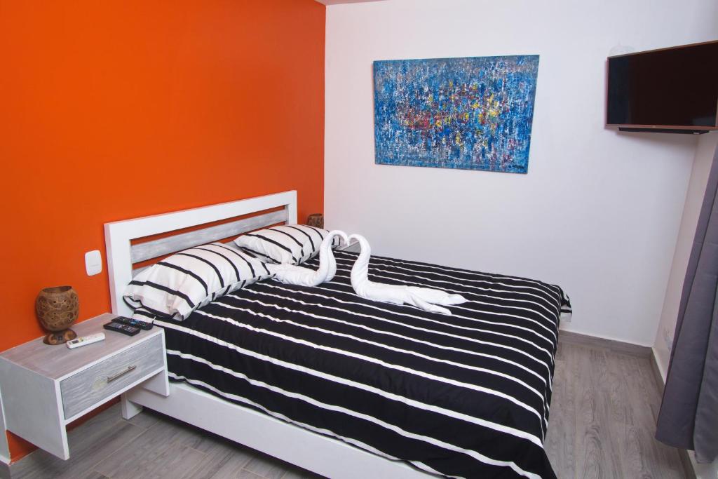 a bedroom with a bed with black and white stripes at La Aldea in Santo Domingo