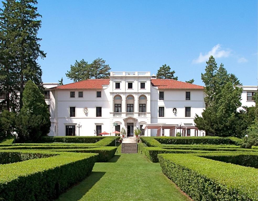 a large white building with hedges in front of it at Geneva On The Lake Boutique Resort Hotel in Geneva