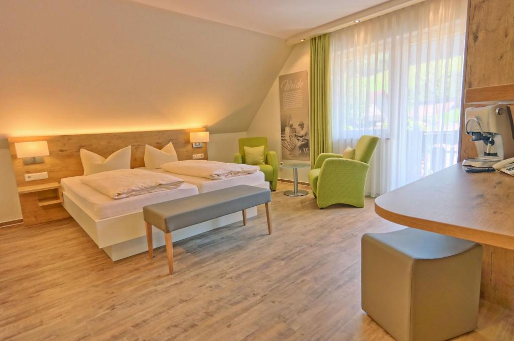 a hotel room with a bed and a desk at Hotel Garni Bergblick in Biberach bei Offenburg