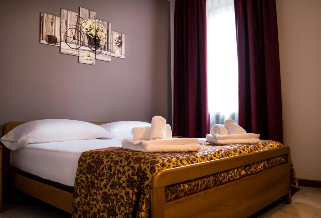 Hotel Corte Dal Castello في كولا دي لاتيزي: غرفة نوم عليها سرير وفوط