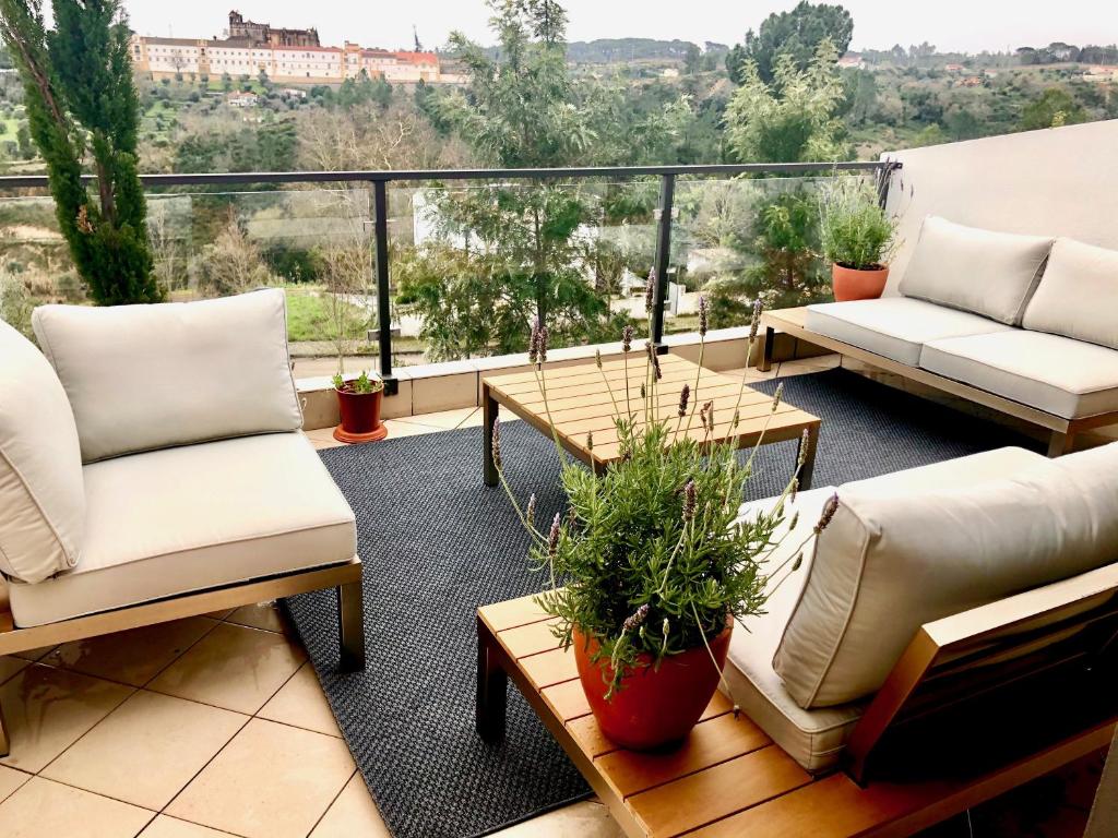 einen Balkon mit Sofas und Tischen und Aussicht in der Unterkunft Guesthouse do Sol - Luxury Villa in Tomar