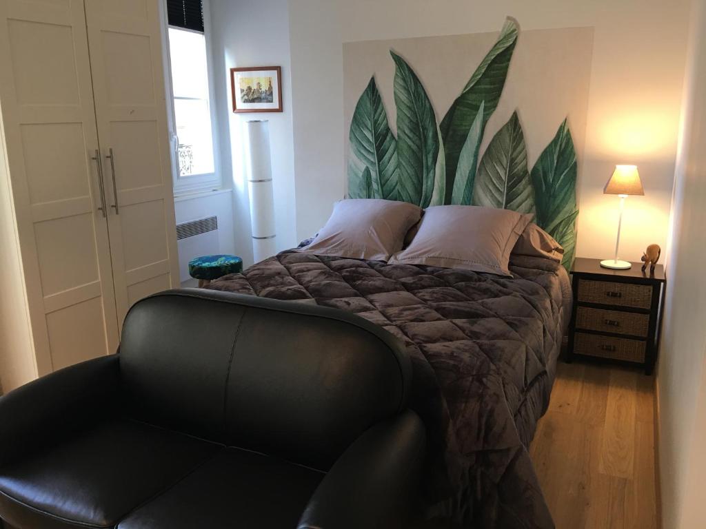 ein Schlafzimmer mit einem Bett mit einer Pflanze an der Wand in der Unterkunft Joli et agréable studio in Bordeaux