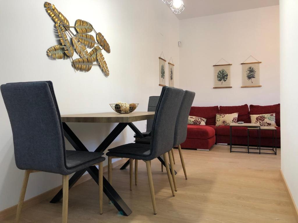 Un comedor con una mesa y sillas y un sofá. en APARTAMENTOs IGLESIA DE SANTIAGO, en Jerez de la Frontera