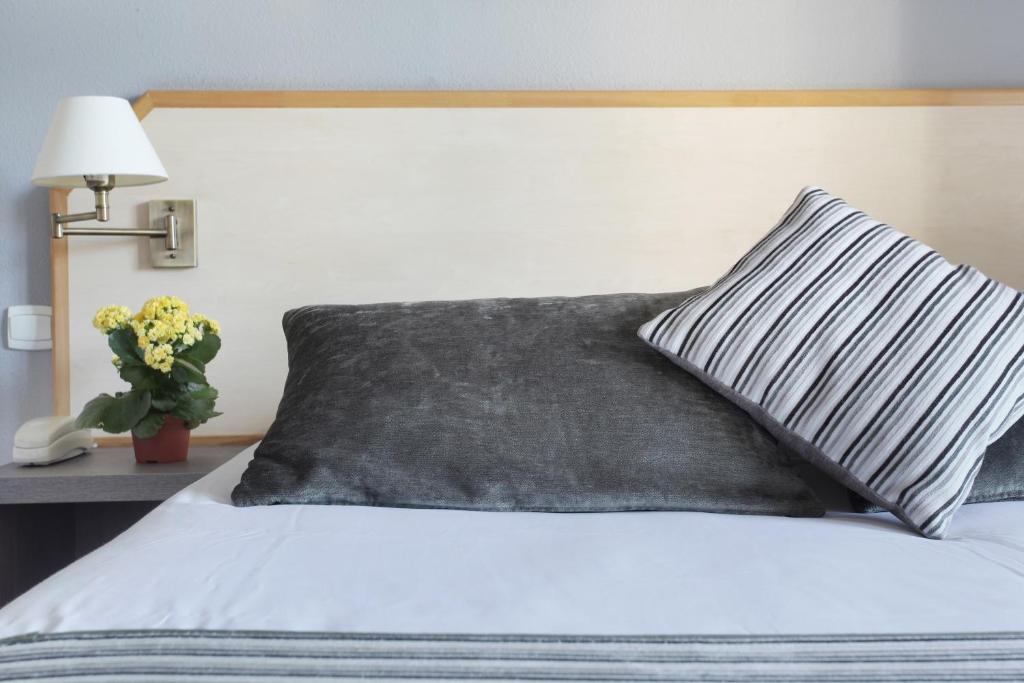 Postel nebo postele na pokoji v ubytování Logis Hôtel Le Rodin
