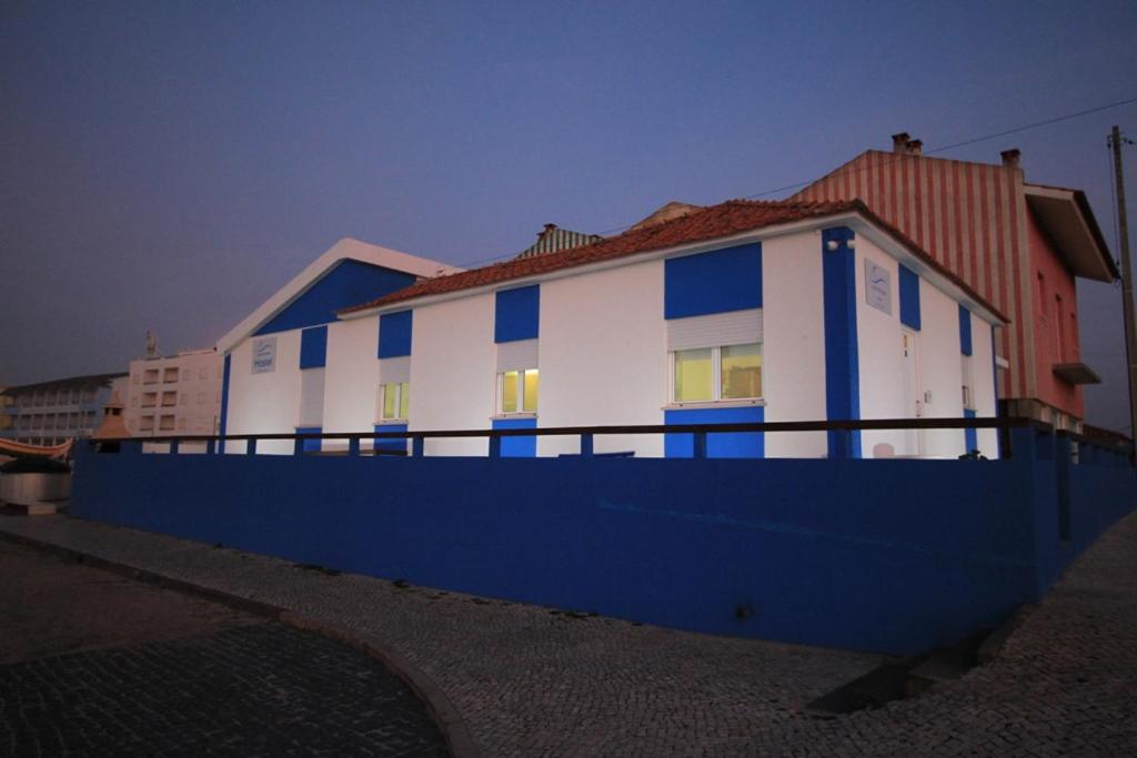 uma casa branca e azul com uma cerca azul em Casa da Praia em Praia da Vieira