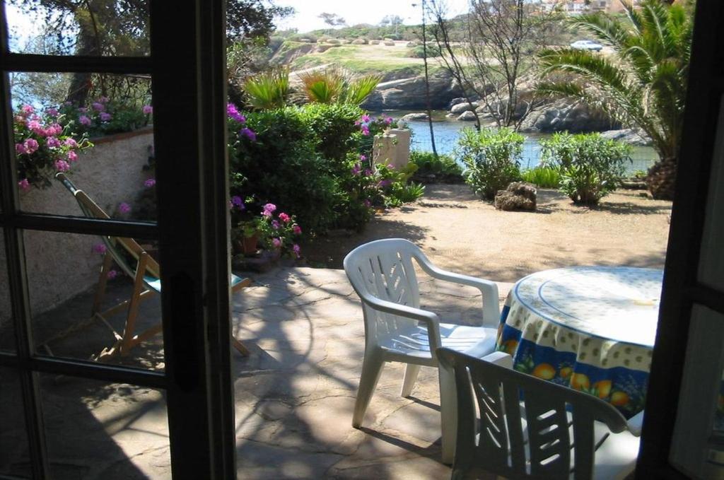 d'une terrasse avec une table et des chaises et une vue sur le jardin. dans l'établissement LE BIJOU 111, aux Issambres