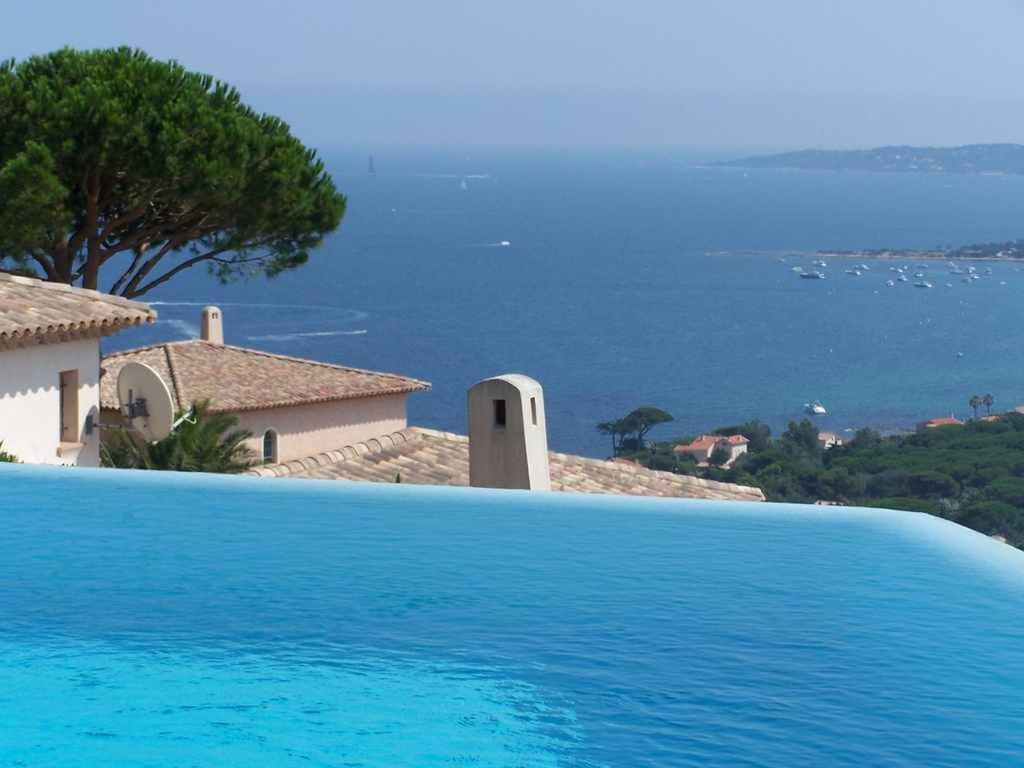 - une piscine en face d'une maison avec vue sur l'océan dans l'établissement Villa Deux -141, à Sainte-Maxime