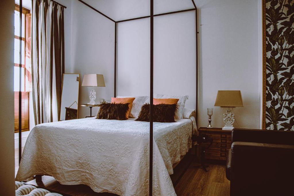 una camera da letto con un grande letto e un grande specchio di HOTEL LUZ ALMONASTER ad Almonaster la Real