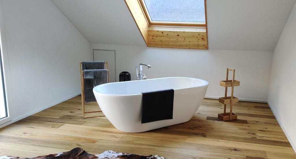 a large white bath tub in a room with a window at Schöne Wohnung in Walenstadt in Walenstadt