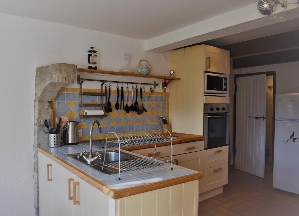 a kitchen with a sink and a stove top oven at Les Hirondelles in Pont-de-Barret