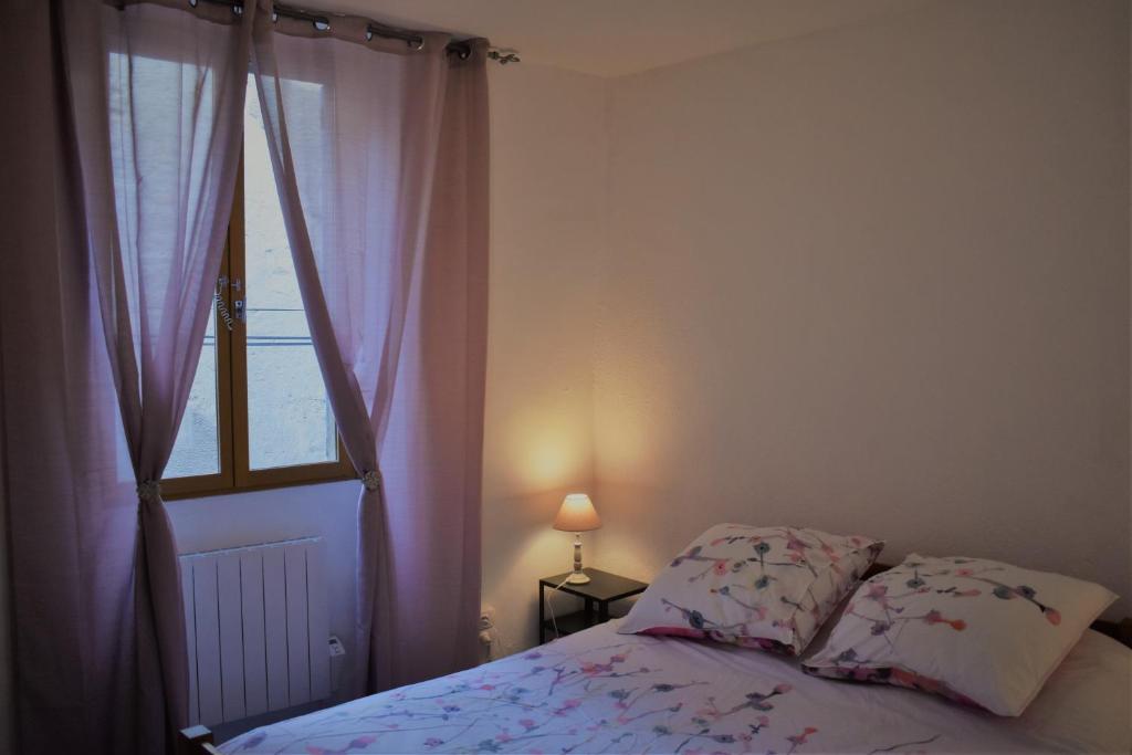 a bedroom with a bed next to a window at Les Hirondelles in Pont-de-Barret