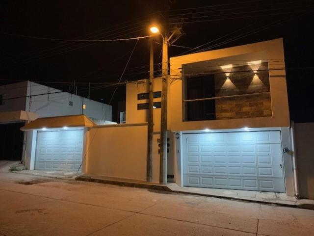 zwei Garagentüren an einem Haus in der Nacht in der Unterkunft LOMAS SUITES in Ciudad Valles