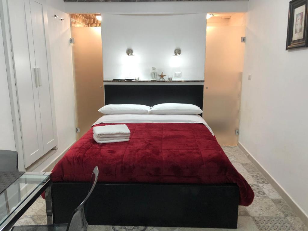 a bedroom with a bed with a red blanket at BEAUTIFUL in Taormina