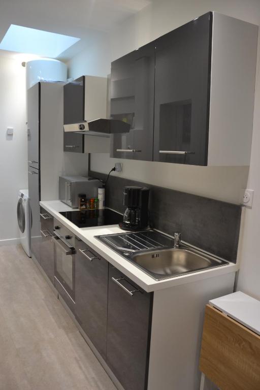 une petite cuisine avec un évier et une cuisinière dans l'établissement Petit T2 hypercentre avec terrasse privée - 006, à Rouen