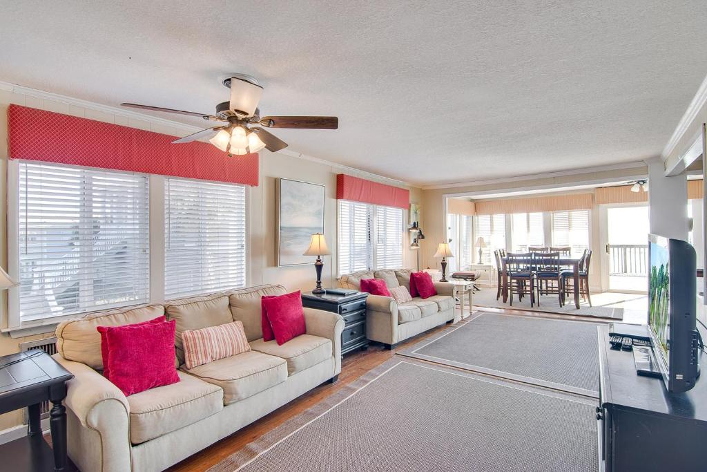 a living room with a couch and a ceiling fan at Just Beachy in Folly Beach