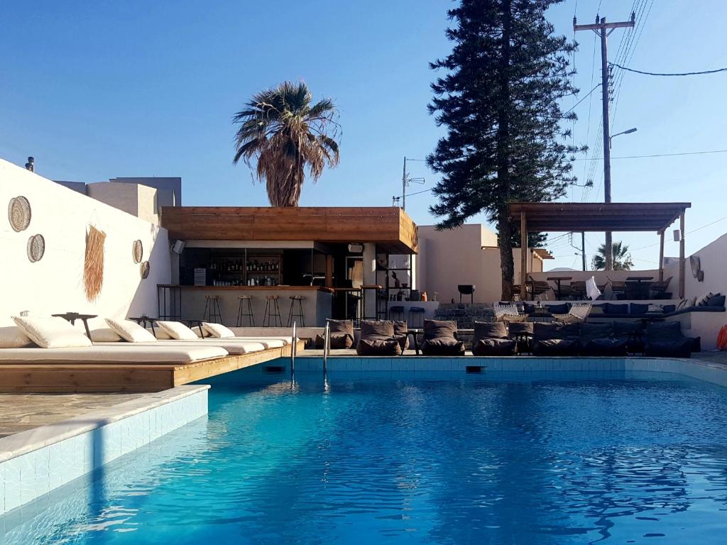 basen z leżakami i ośrodek w obiekcie Mira Living Concept Suites Adults Only w mieście Kokkini Hani