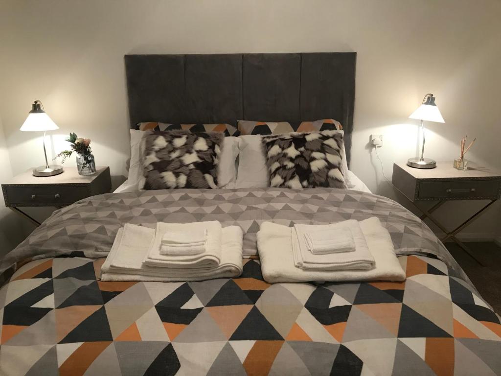 a bedroom with a large bed with towels on it at Cosy & Lovely Guesthouse with Free Parking & Close to Station in Slades Green