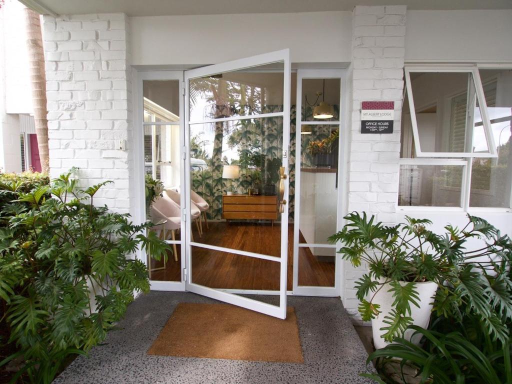 a pivot door in a house with plants at Mt Albert Motor Lodge in Auckland