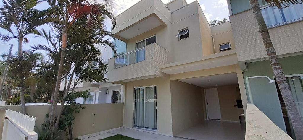 a large building with palm trees in front of it at sobrado Bege - Mariscal in Bombinhas