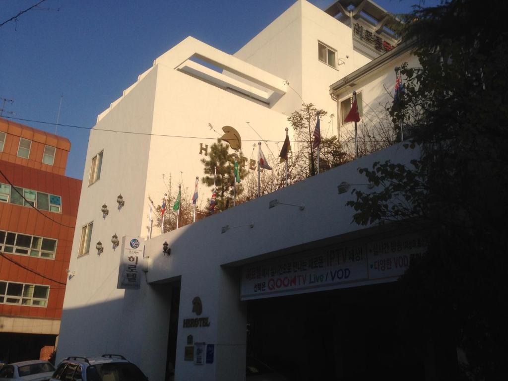 a white building with a balcony on top of it at Daegu Goodstay Herotel in Daegu