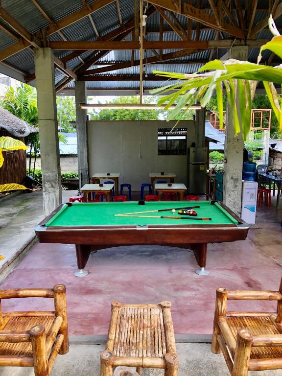 un tavolo da ping pong e due sedie in una stanza di Sharky Hostel Oslob a Oslob