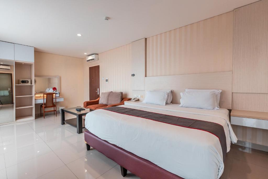 a hotel room with a large bed and a kitchen at Super OYO Collection O 26 Hotel Igloo in Bekasi