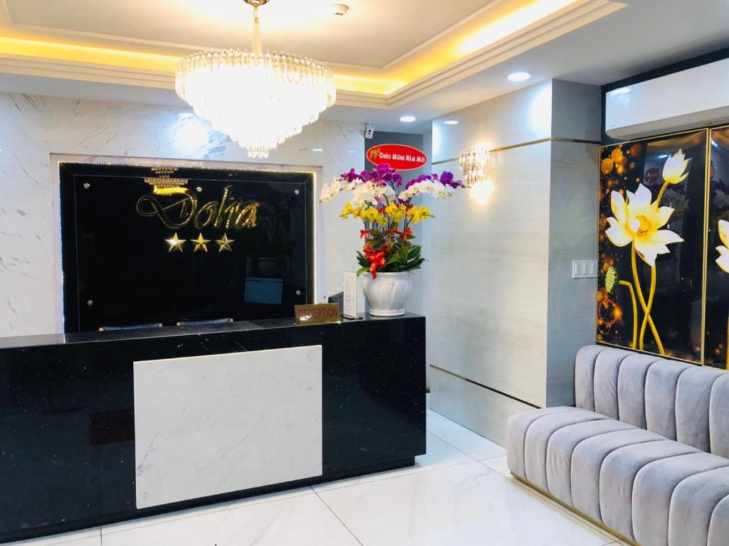 een lobby met een receptie met bloemen en een kroonluchter bij Doha 2 Hotel Saigon Airport in Ho Chi Minh-stad