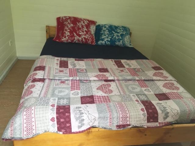 a bed with a quilt on it in a room at kaze manouilh in Hell-Bourg