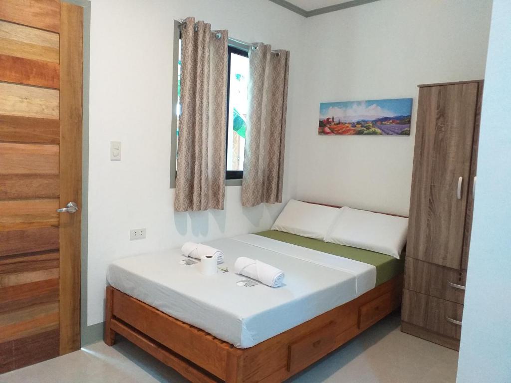 um pequeno quarto com uma cama e uma janela em GREENSPACE em Panglao