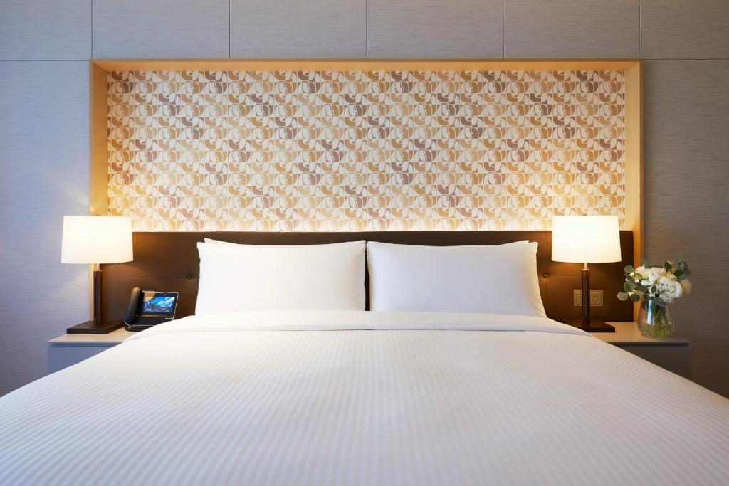 Postel nebo postele na pokoji v ubytování Landing Jeju Shinhwa World Hotel