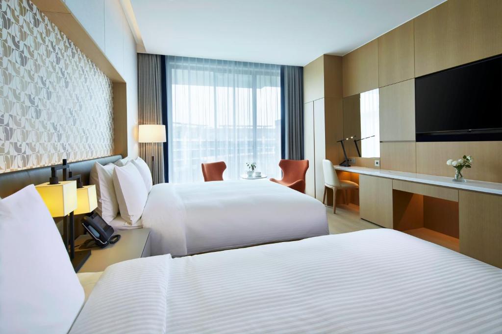 Postel nebo postele na pokoji v ubytování Landing Jeju Shinhwa World Hotel