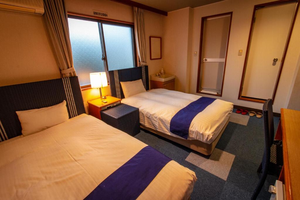 Postel nebo postele na pokoji v ubytování SPA Inn Shirahama