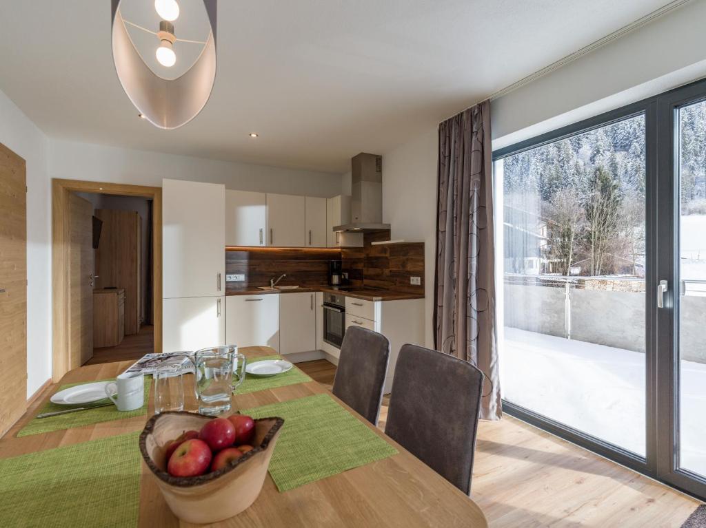 kuchnia i jadalnia ze stołem i misą owoców w obiekcie Appartement Strasser w mieście Söll