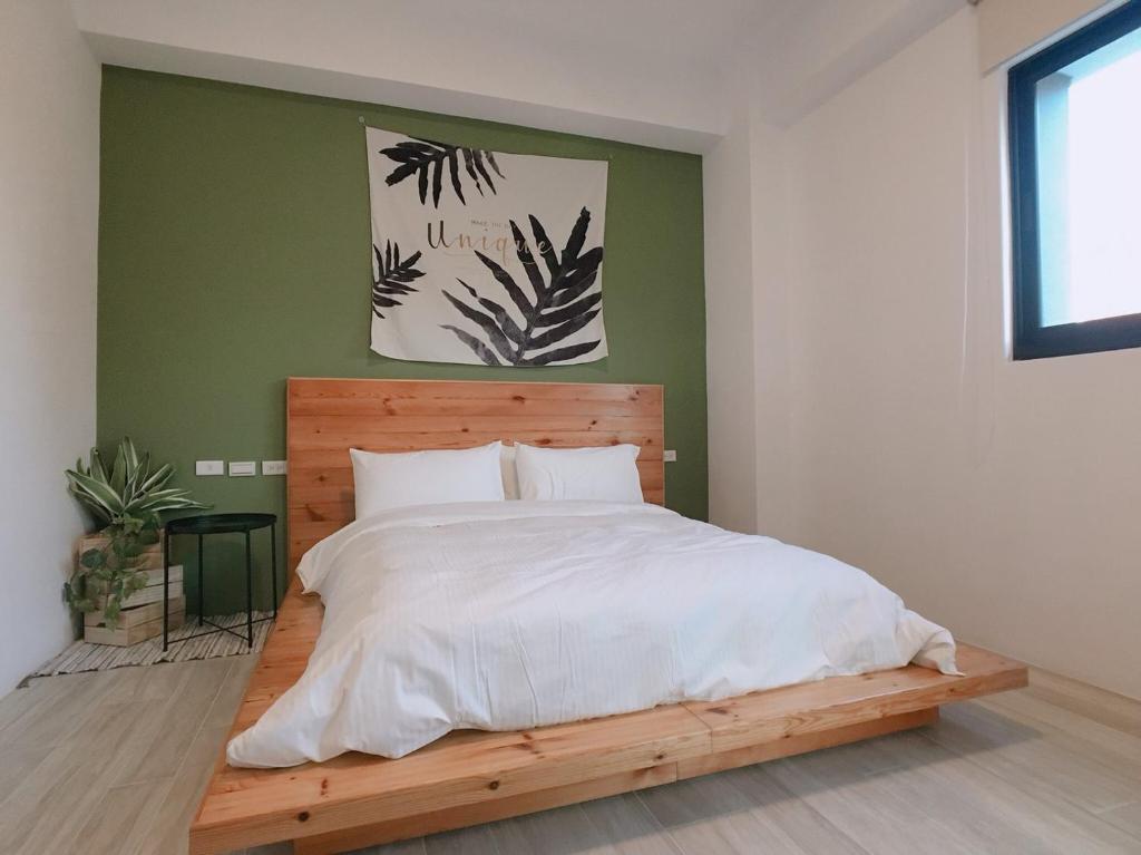 um quarto com uma cama grande e uma cabeceira em madeira em 水蛙春 em Hengchun Old Town