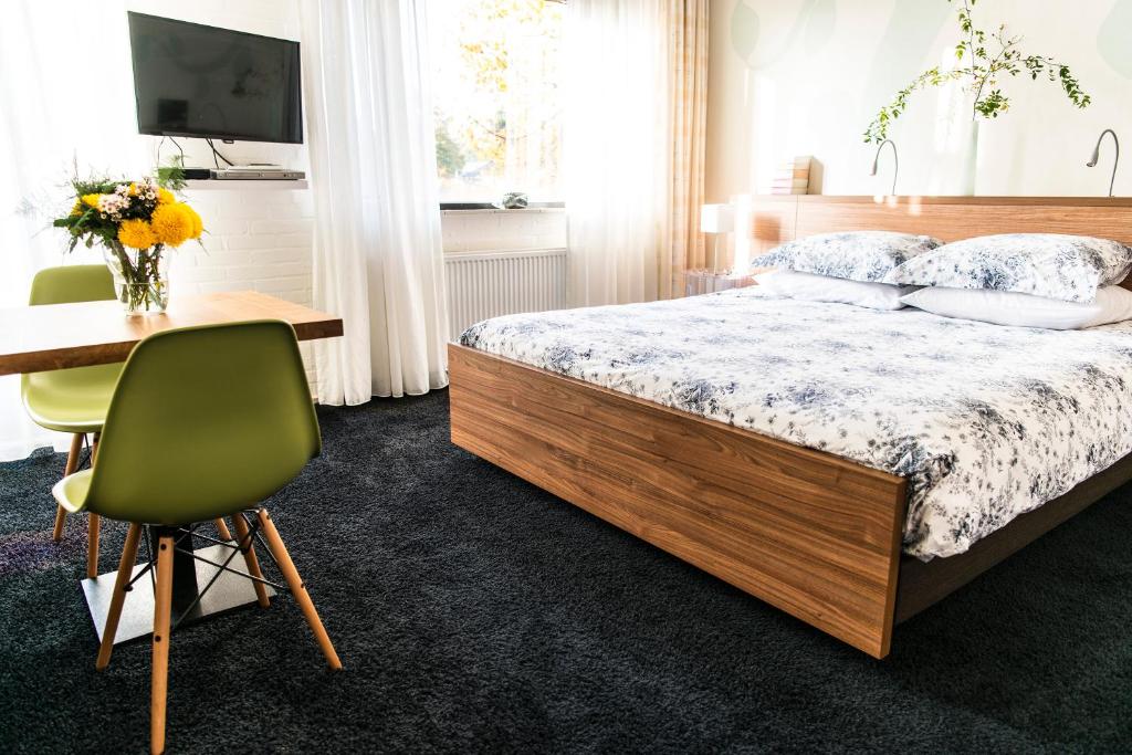 a bedroom with a bed and a desk and a chair at B&B De Dream in Leeuwarden