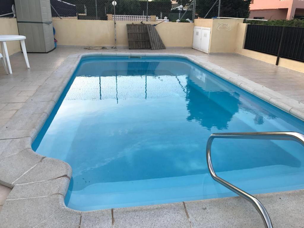 una piscina con agua azul en un patio trasero en APARTAMENTO PEÑISCOLA, en Peñíscola