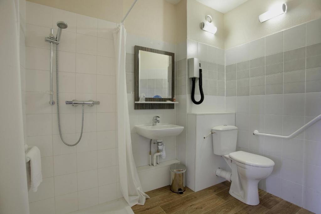 a bathroom with a toilet and a shower and a sink at The Originals City, Hôtel L&#39;Acropole, Saint-Etienne Sud (Inter-Hotel) in La Ricamarie