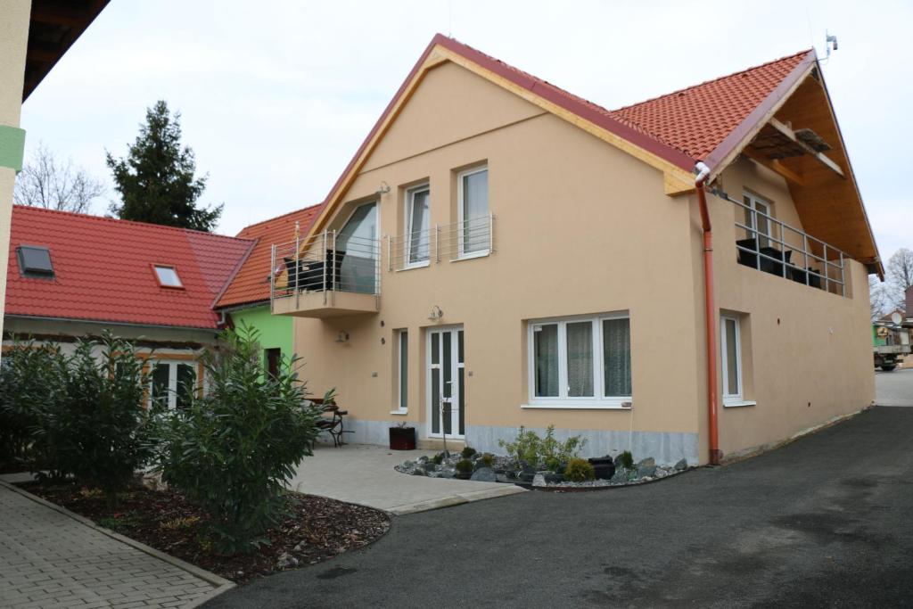 uma casa com um telhado vermelho em Penzion Kotvas em Milovice