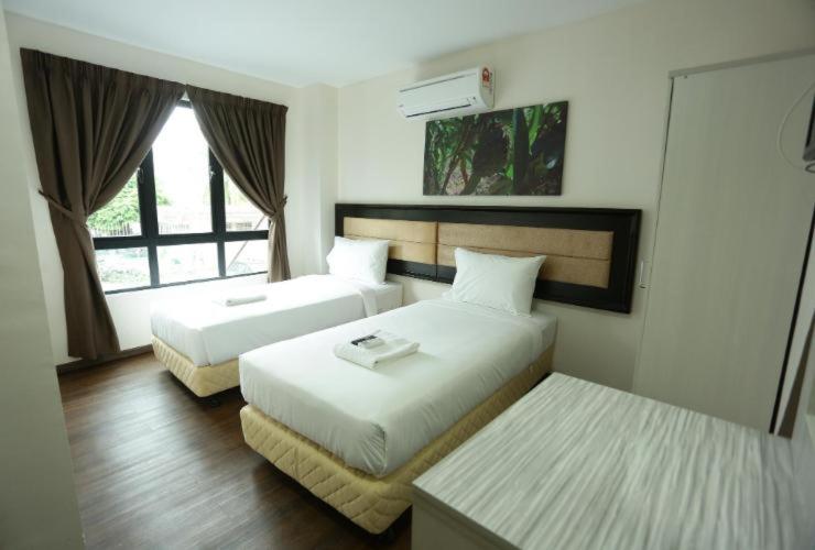 a hotel room with two beds and a window at Yeob Bay hotel Ampang in Ampang