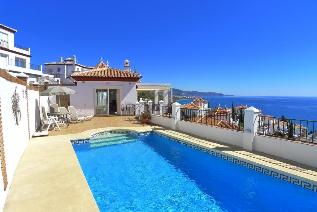 uma villa com piscina e vista para o oceano em Villa Ladera em Torrox