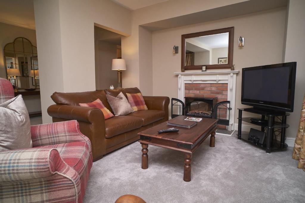 a living room with a couch and a fireplace at Old Bakers Cottage ground floor apartment centrally located in Grasmere with patio area in Grasmere