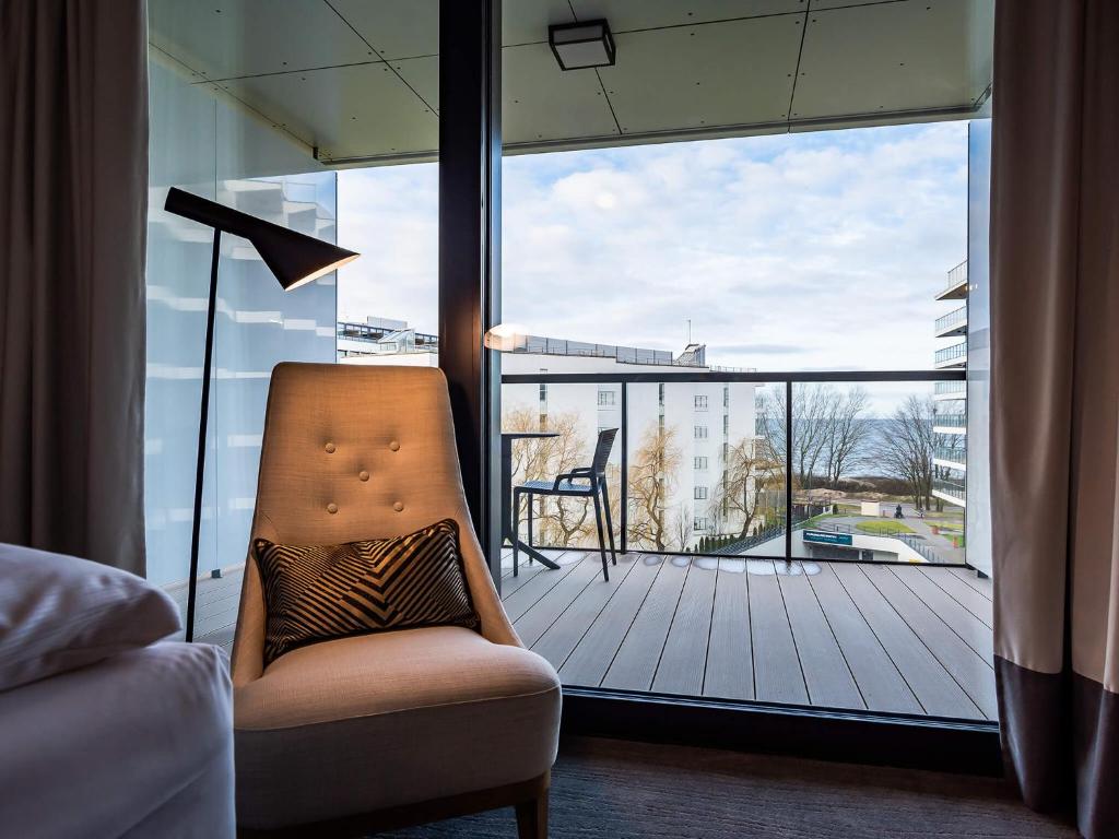 コウォブジェクにあるVacationClub – Seaside Apartament 348のバルコニーを望む客室内の椅子