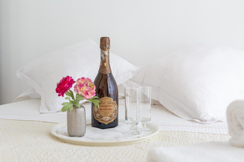- une bouteille de vin et deux verres sur le lit dans l'établissement Lovely apartment near the sea 25 bis Promenade des Anglais, à Nice