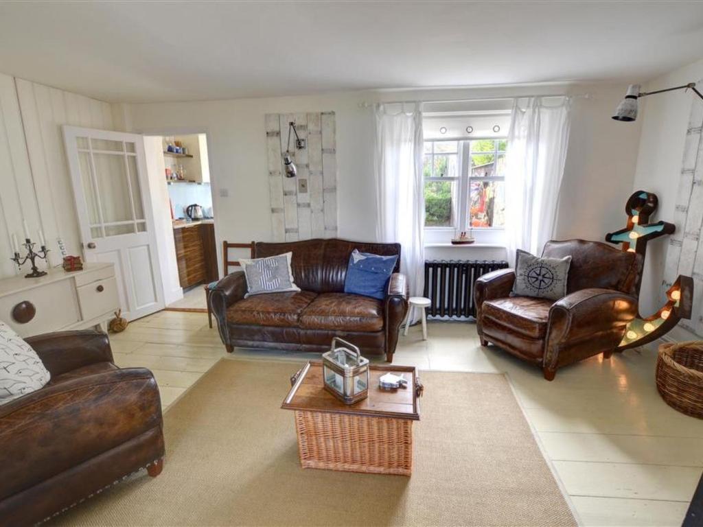 a living room with leather furniture and a table at Holiday Home Kingsgate Bay by Interhome in Kingsgate