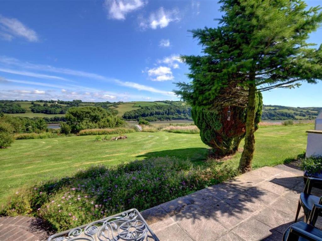 a view from the patio of a home with a tree at Holiday Home Llangain by Interhome in Llangain