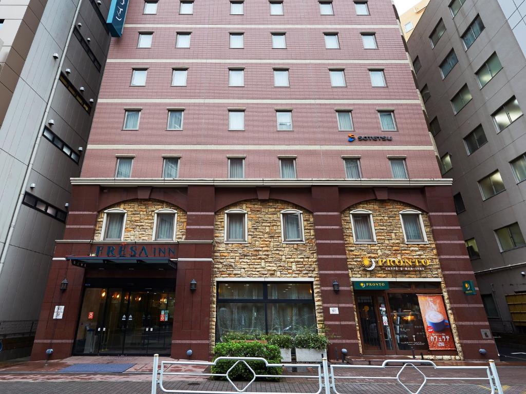 a large brick building with a clock on the front of it at Sotetsu Fresa Inn Nihombashi Kayabacho in Tokyo