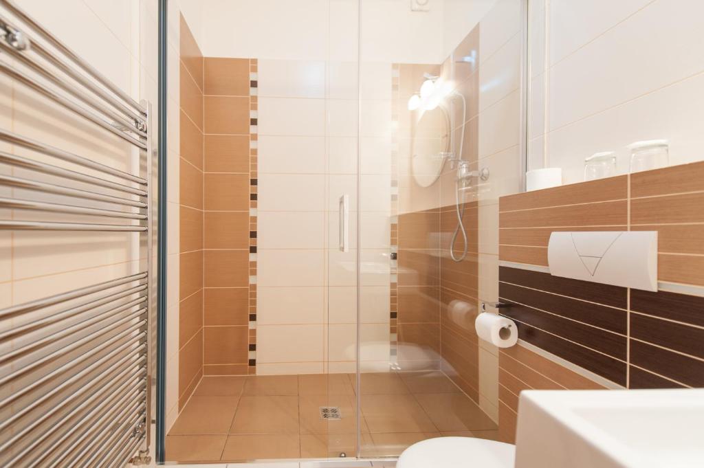 ein Bad mit einer Dusche und einem WC in der Unterkunft Hotel v Centru in Budweis