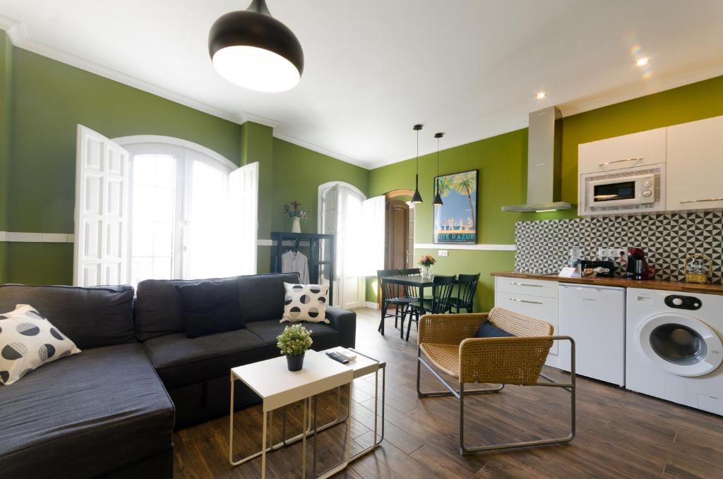 sala de estar con sofá y cocina en Apartamentos Suites Roma en Mérida
