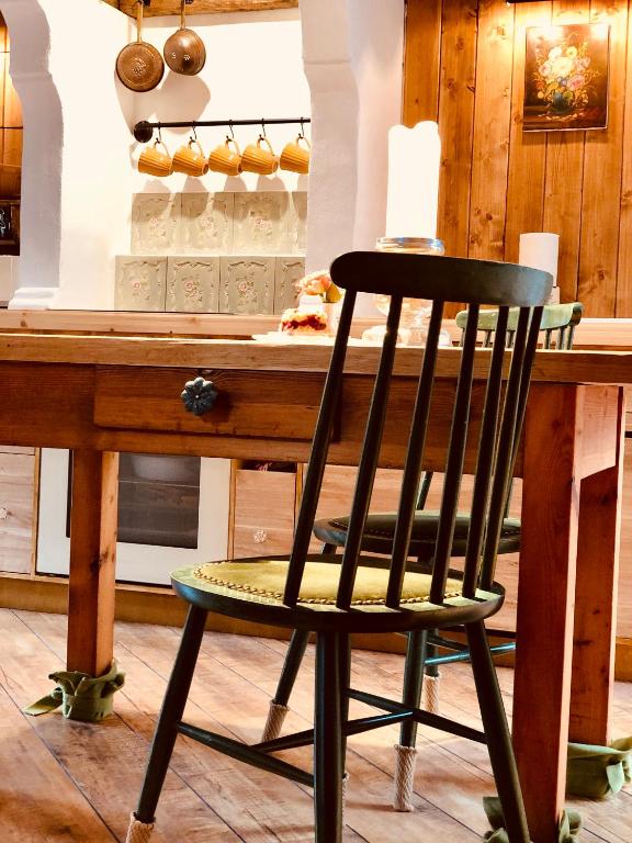 a black chair sitting in front of a wooden table at Weißt Du noch - Gästehäuser & Suiten in Kühlungsborn